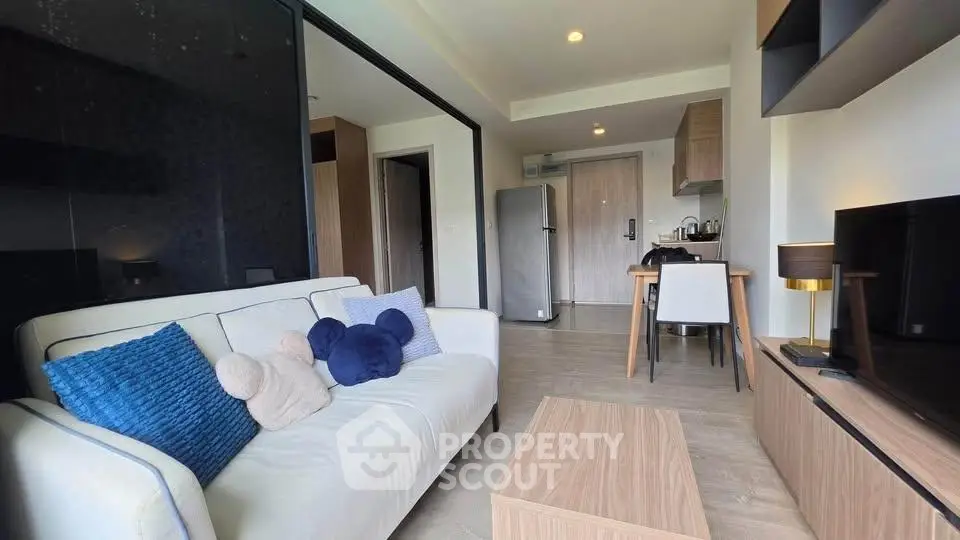 Modern living room with cozy sofa and open kitchen layout in stylish apartment.