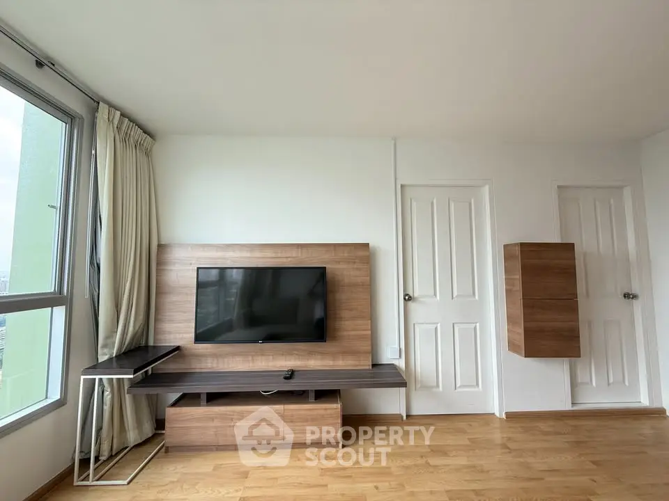 Spacious living room with modern TV unit and large window for natural light.