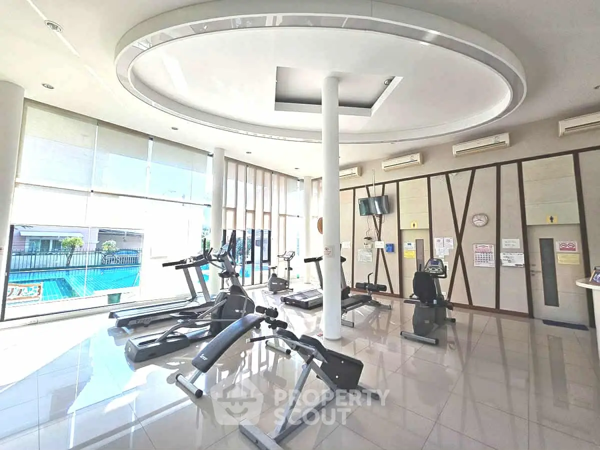 Spacious modern gym with pool view in luxury apartment complex