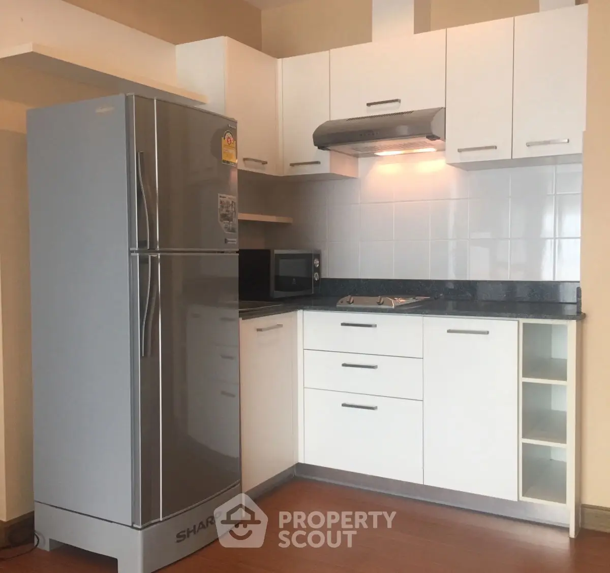Modern kitchen with sleek appliances and stylish cabinetry in a cozy apartment setting.