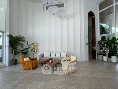 Modern living room with stylish furniture and indoor plants, featuring a cozy seating area and elegant decor.