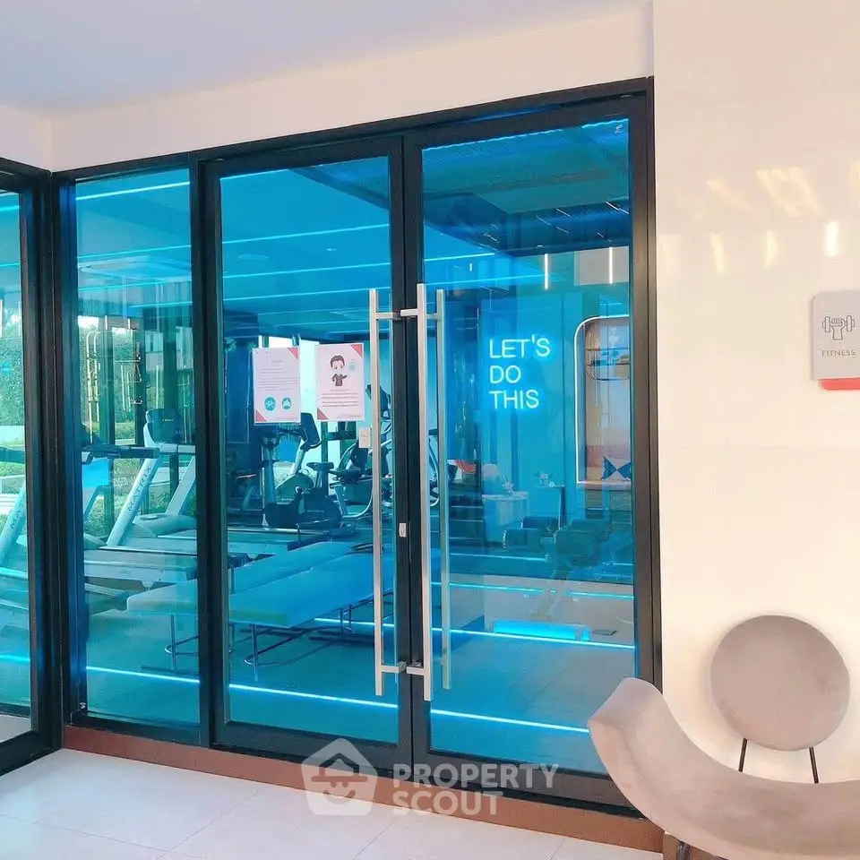 Modern gym with glass doors and motivational neon sign in luxury building