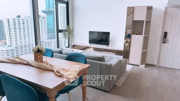 Modern living room with city view, stylish furniture, and natural light in high-rise apartment.