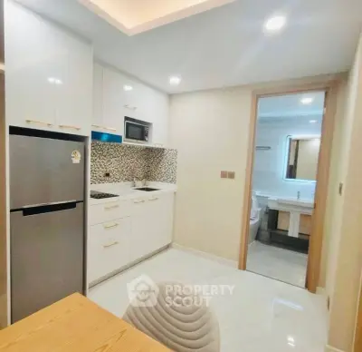 Modern kitchen with sleek appliances and open layout adjacent to a bathroom