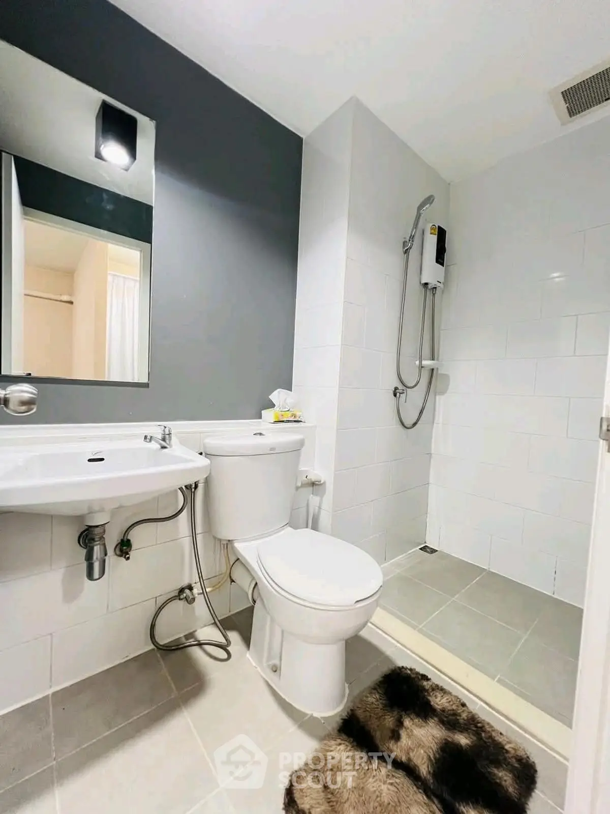 Modern bathroom with sleek design, featuring a shower, toilet, and stylish sink.