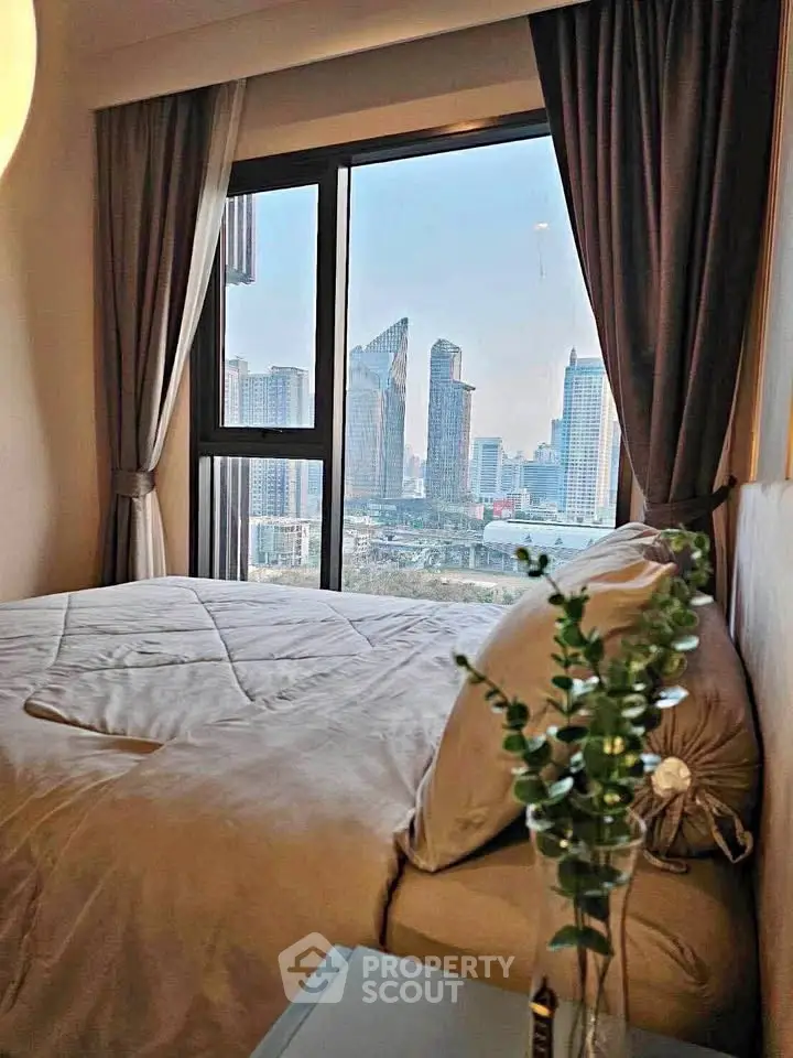 Luxurious bedroom with stunning city view from large window, elegant decor and cozy ambiance.