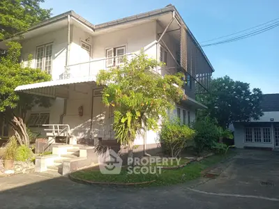 Charming two-story house with lush garden and spacious driveway in serene neighborhood.