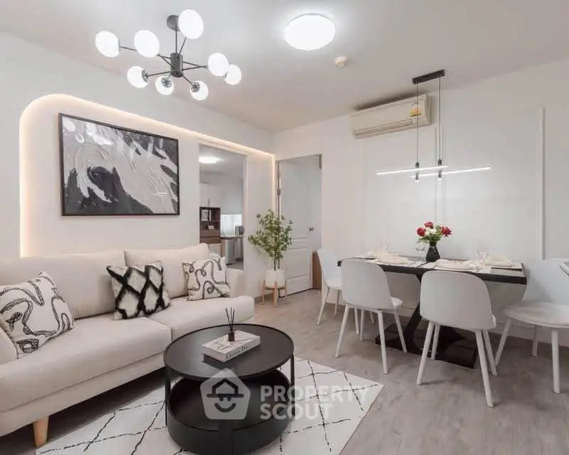 Modern living room with stylish decor and dining area, featuring elegant lighting and contemporary furniture.
