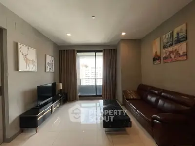 Spacious living room with modern decor and large window offering city views.