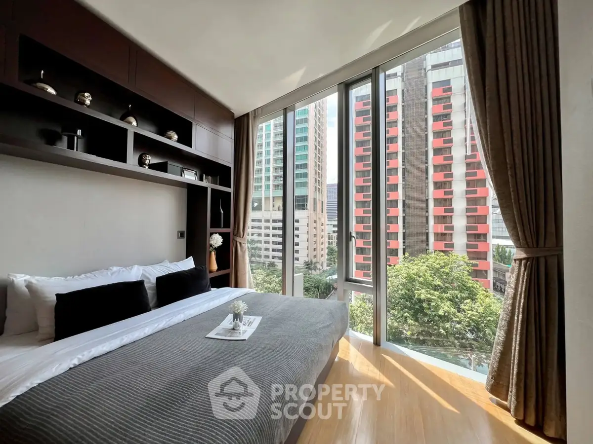 Luxurious bedroom with floor-to-ceiling windows offering stunning city views.