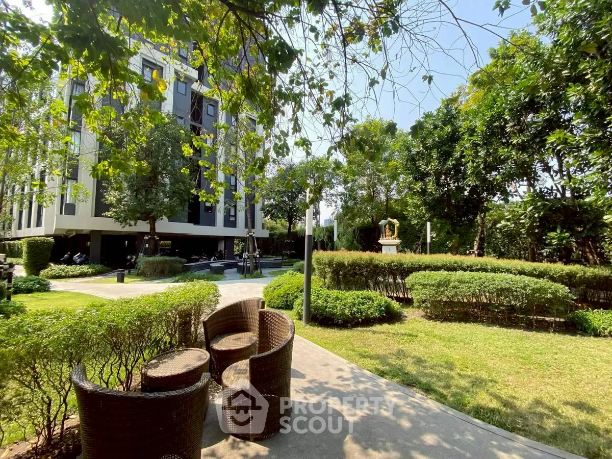 Modern apartment building with lush garden and outdoor seating area