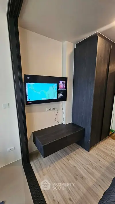Modern living room with wall-mounted TV and sleek storage unit
