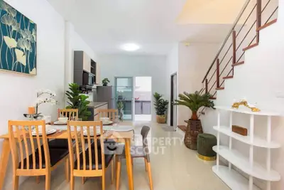 Modern open-plan dining and kitchen area with stylish decor and staircase
