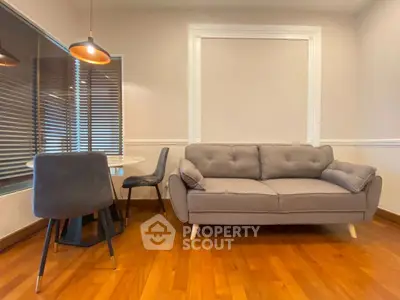 Cozy living room with modern gray sofa and dining area, perfect for relaxation.