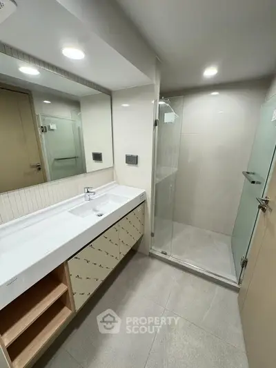 Modern bathroom with sleek design, glass shower, and spacious vanity in a contemporary home.