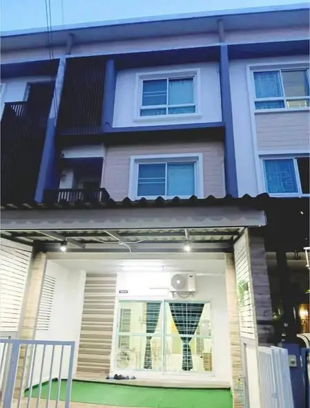 Modern three-story townhouse with stylish facade and balcony, perfect for urban living.