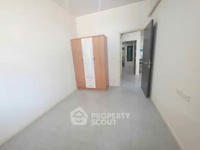 Spacious bedroom with wardrobe and open door leading to hallway