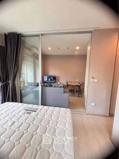 Modern studio apartment with sliding glass partition, cozy living area, and elegant decor.