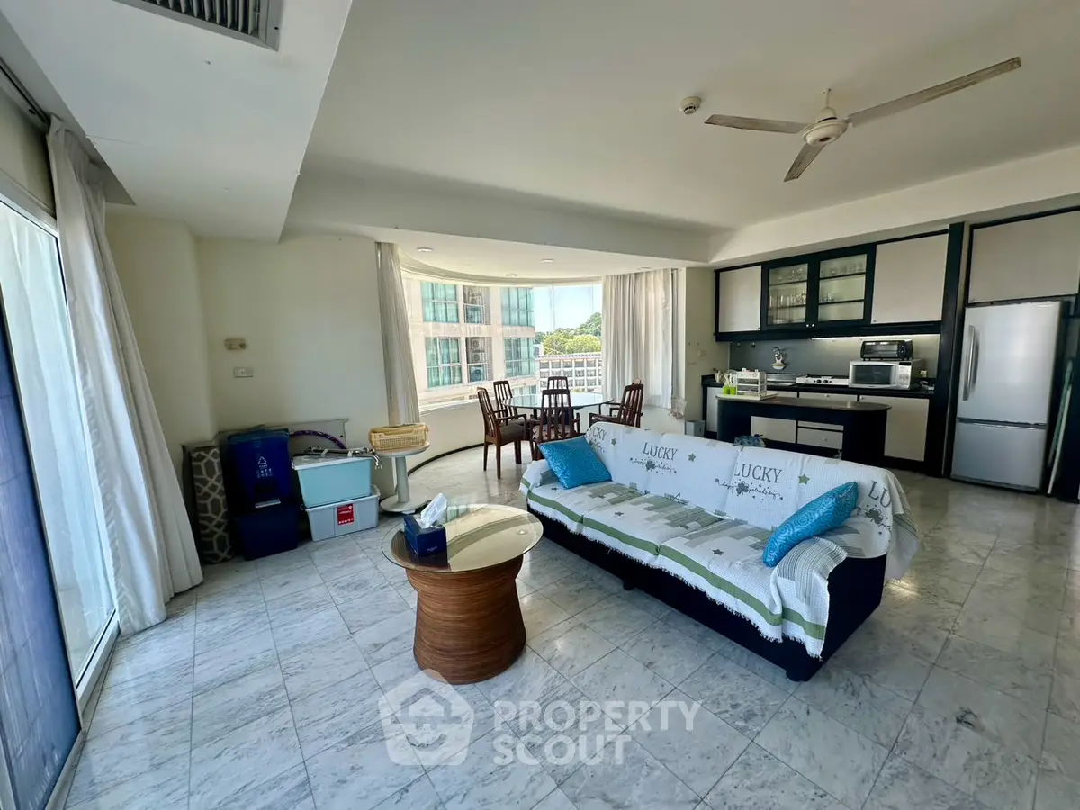 Spacious living room with open kitchen and large windows offering city views