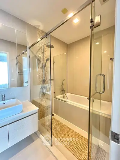 Modern bathroom with glass shower and bathtub in luxury apartment