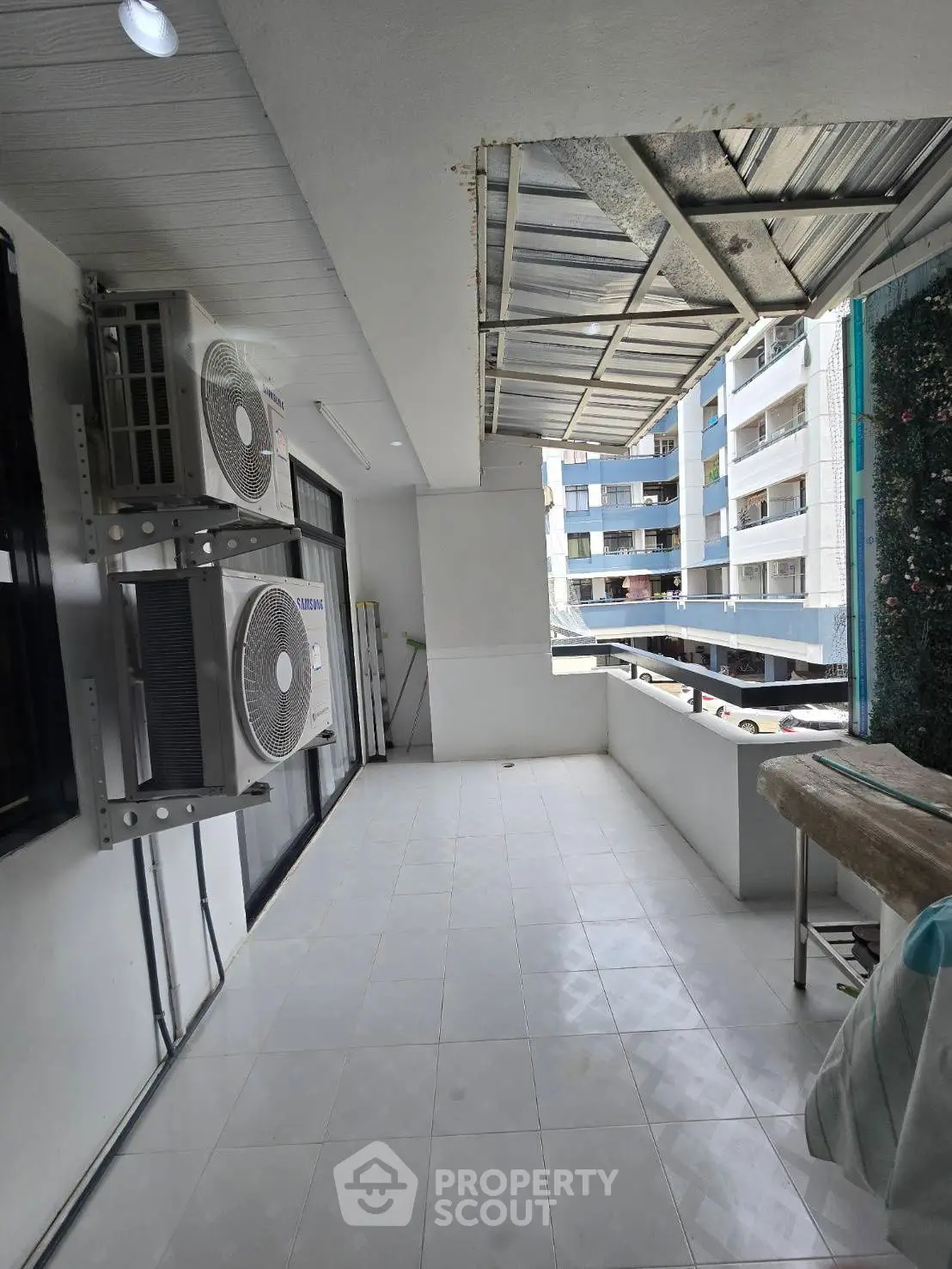Spacious balcony with city view and air conditioning units