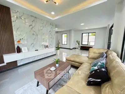 Spacious modern living room with elegant marble accent wall and cozy beige sectional sofa.