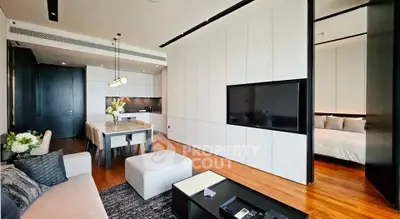 Modern open-plan living room with sleek kitchen and dining area, featuring elegant decor and natural light.