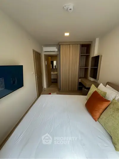 Modern bedroom with stylish decor and built-in wardrobe in a cozy apartment.