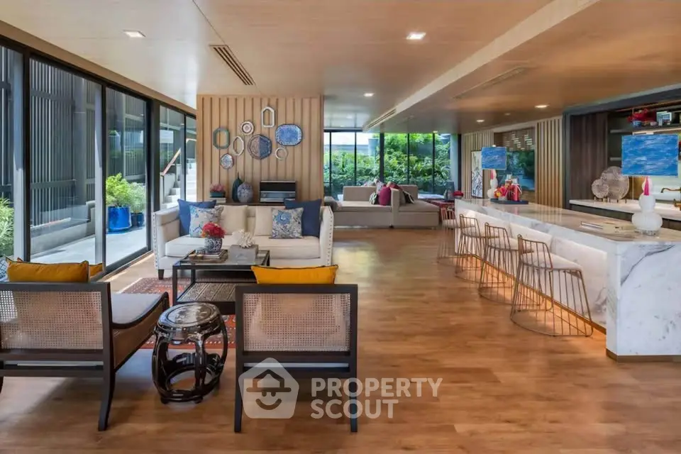 Luxurious open-plan living room with modern decor and large windows offering garden views.