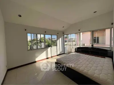 Spacious bedroom with large windows and natural light in modern home.