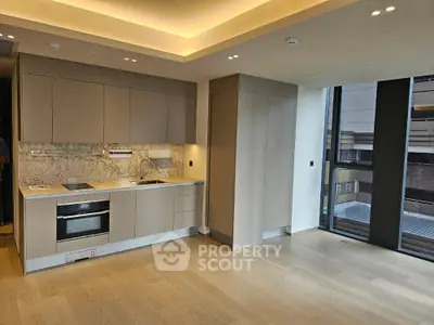 Modern kitchen with sleek cabinetry and built-in appliances in luxury apartment.