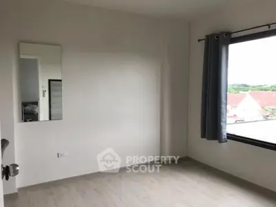 Spacious empty room with large window and scenic view, perfect for customization.