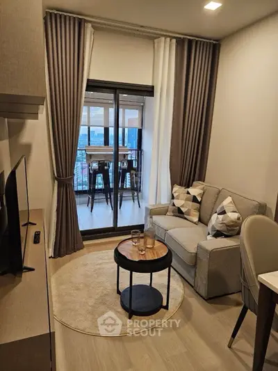 Chic modern living room with balcony view, cozy sofa, and stylish decor.