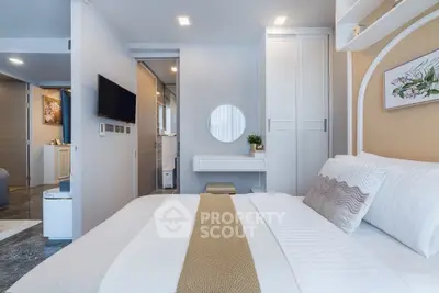 Modern bedroom with stylish decor and built-in storage, featuring a cozy bed and sleek TV setup.