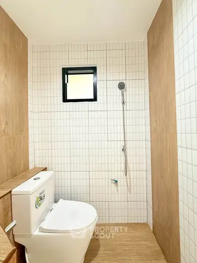 Modern bathroom with sleek white tiles and wooden accents