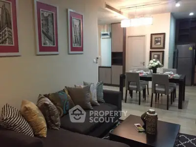 Stylish living room with modern decor and dining area in open layout apartment.