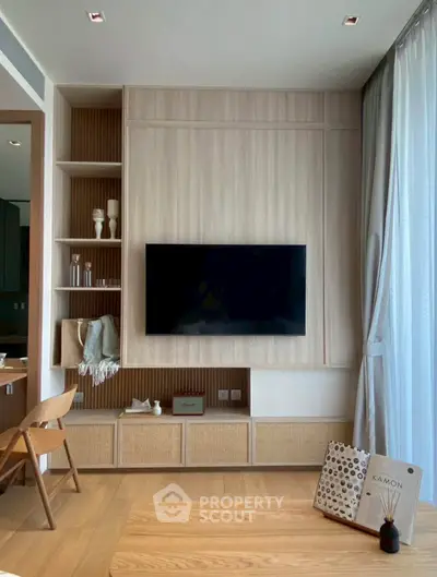 Modern living room with stylish wooden paneling and mounted TV, featuring elegant decor and natural light.