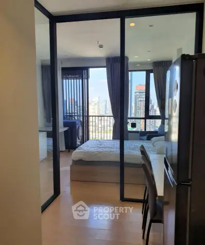 Modern apartment with glass partition, city view, and sleek furnishings