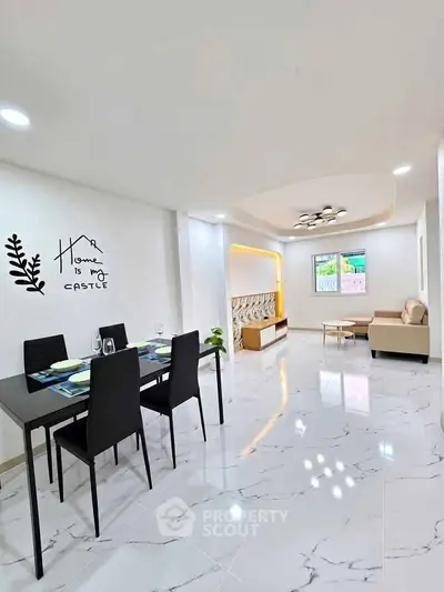 Modern open-plan living and dining area with stylish decor and elegant lighting.