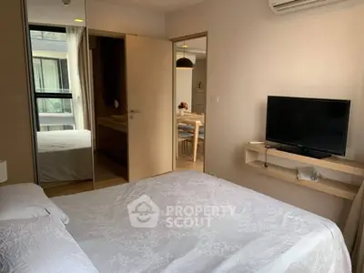 Cozy bedroom with modern decor and a view into a stylish dining area, perfect for urban living.