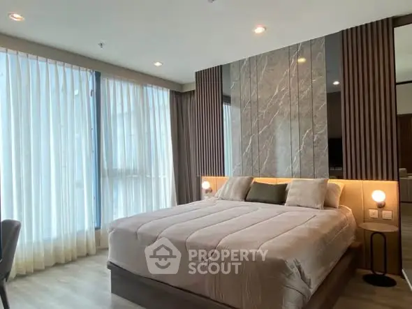 Luxurious bedroom with modern design and large windows offering ample natural light.