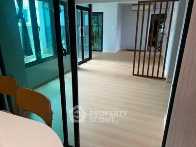 Spacious modern living area with sliding glass doors and wooden flooring