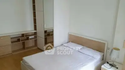 Spacious bedroom with modern furniture and ample storage space.