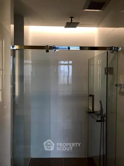 Modern bathroom with glass shower enclosure and sleek lighting