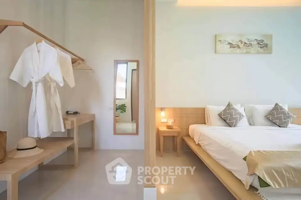 Elegant bedroom with modern decor and open closet, featuring a cozy bed and stylish furnishings.