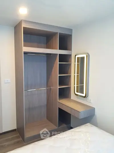 Modern bedroom with built-in wardrobe and illuminated vanity mirror
