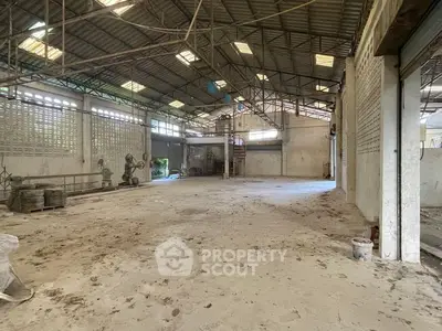 Spacious industrial warehouse with high ceilings and ample natural light, ideal for storage or manufacturing.
