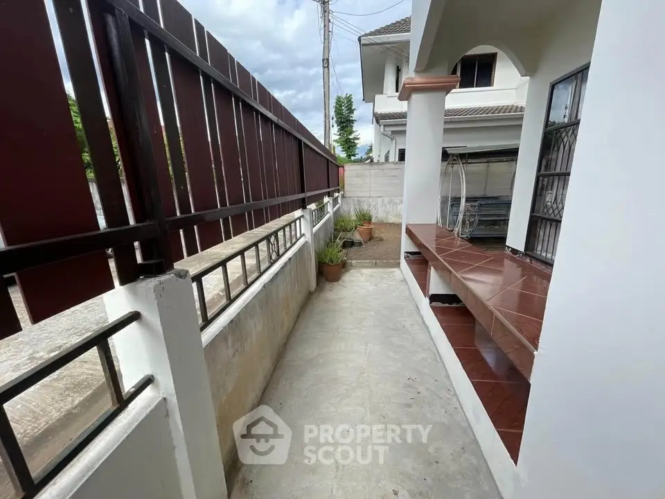 Charming exterior walkway with tiled seating area and garden view