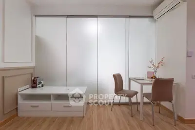 Modern minimalist living space with sleek furniture and frosted glass doors.