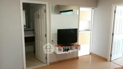 Modern apartment interior with TV, bathroom, and kitchen view